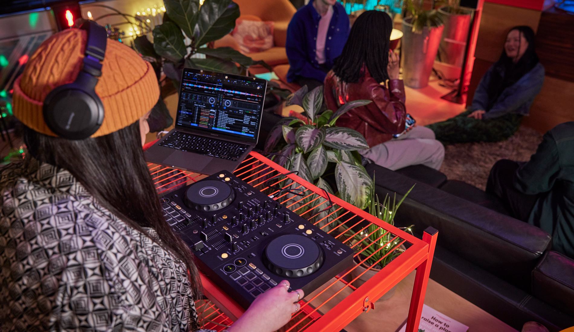Pioneer DJ CDJ players and DJM mixer setup lit in magenta and blue neon